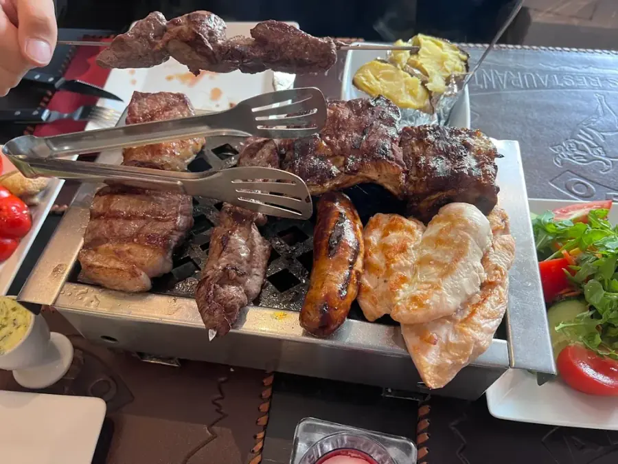 Argentijnse steak op de parrilla, gegrepen door de chef's tang